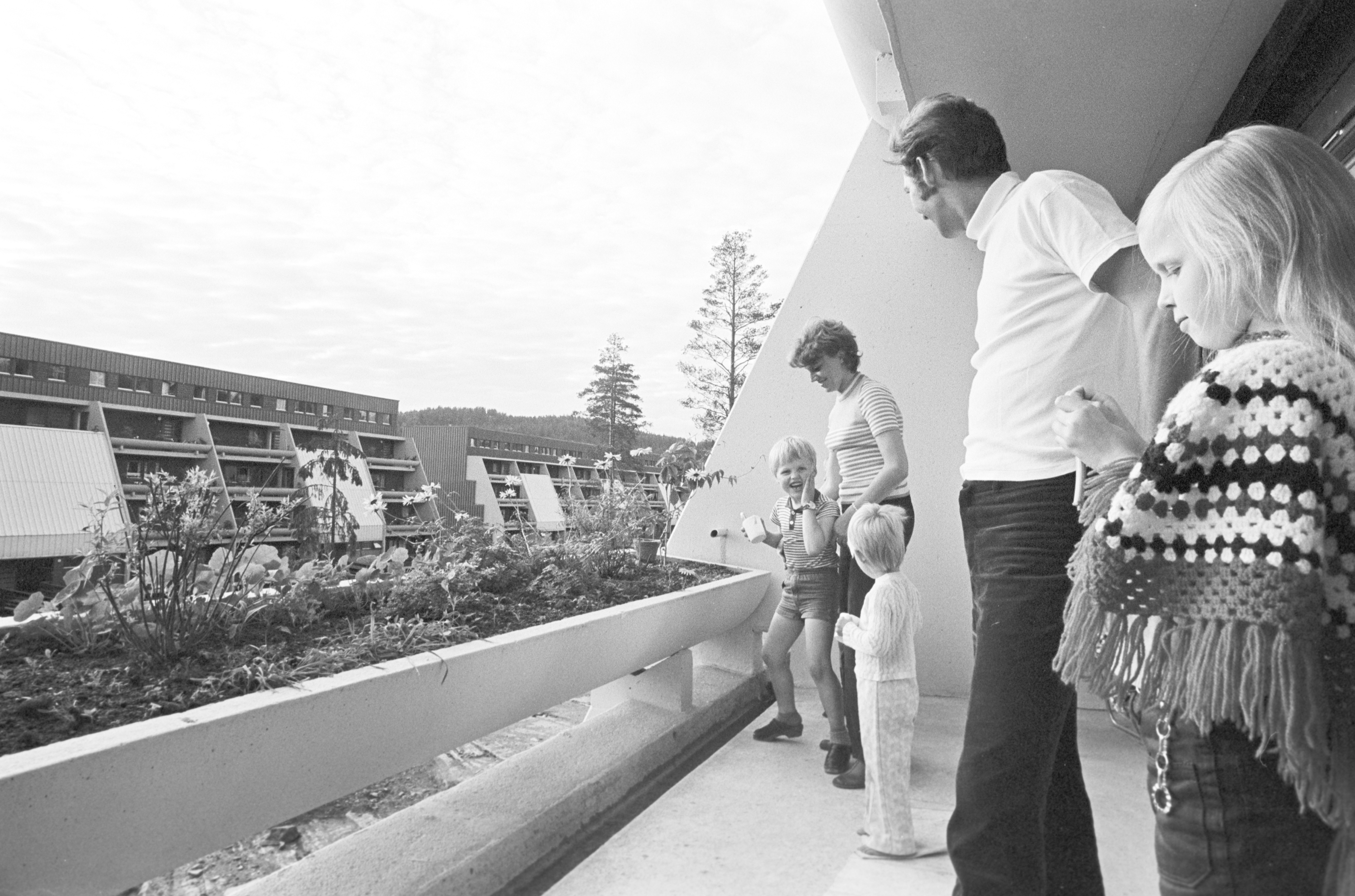 Voksne og barn står på terrasse på Vestlifeltet.